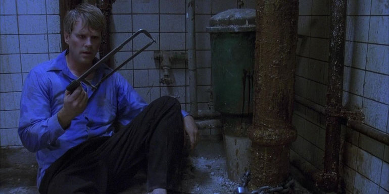 Cary Elwes as Dr. Lawrence Gordon contemplating what to do with a hacksaw in the 2004 horror film Saw