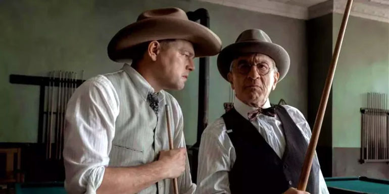 Ernest (Leonardo DiCaprio) looking at William (Robert De Niro), while they play pool in Killers of the Flower Moon.