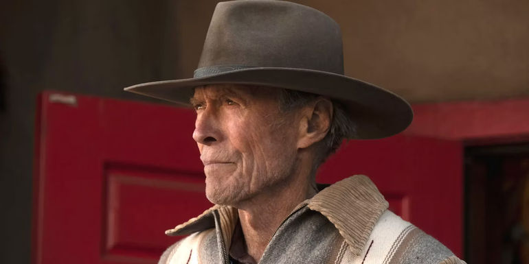 Clint Eastwood in Cry Macho wearing a cowboy hat and gazing pensively into the distance