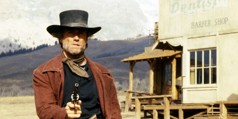 Preacher pointing a gun in Pale Rider
