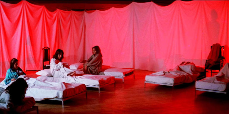 Suzy (Jessica Harper) and the girls in beds in circles surrounded by red curtains in Suspiria.