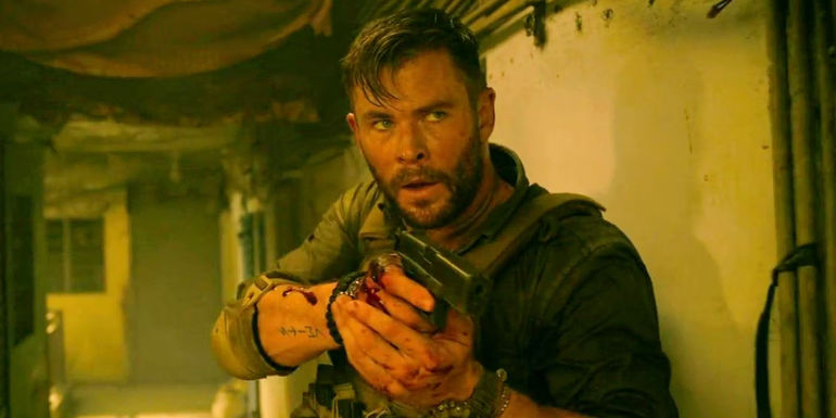 Chris Hemsworth holding a pistol and looking focused in Extraction.