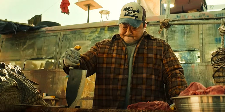 Nam-san cuts up meat at the market in Badland Hunters.