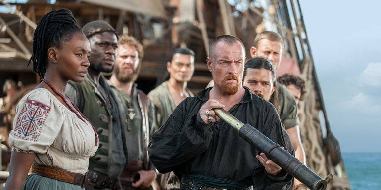  Zethu Dlomo, Toby Stephens, and Luke Arnold at the edge of a ship in Black Sails