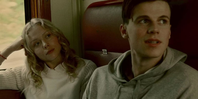 Simon and Marina on a train in The Postcard Killings