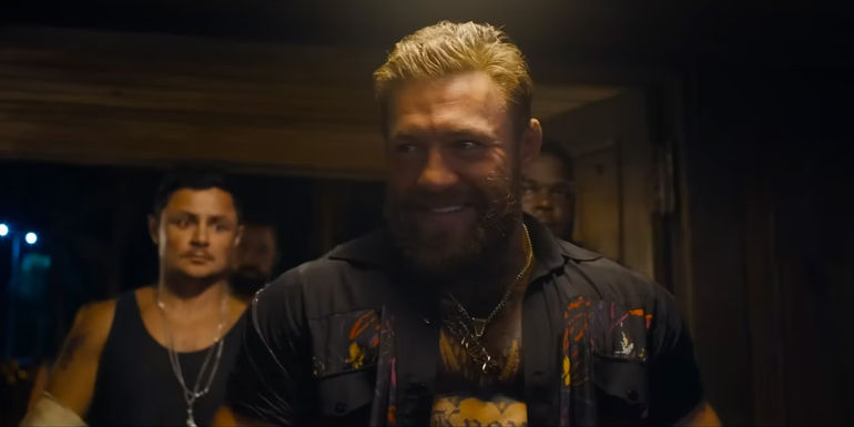 Conor McGregor in Road House entering through the door with his squad and smiling