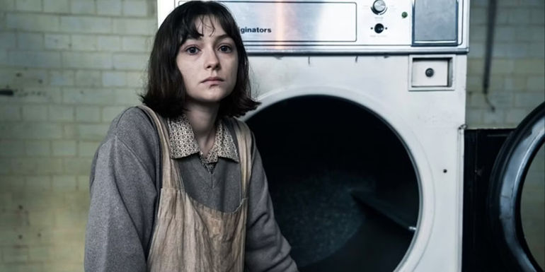 Amy Fitz as Young Lorna in front of the laundry machine in The Woman In The Wall