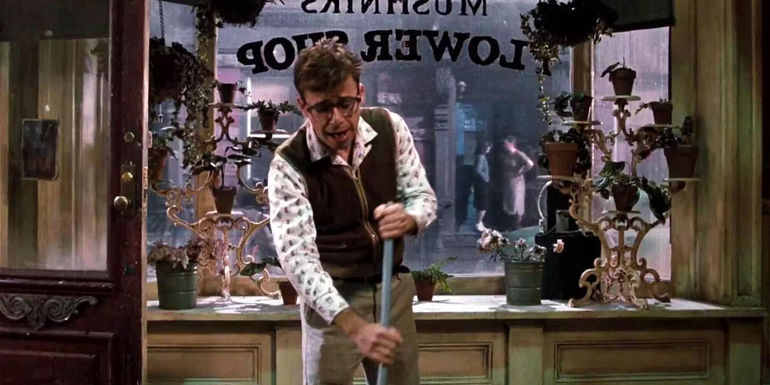 Seymour (Rick Moranis) sweeping in the flower shop in Little Shop of Horrors.