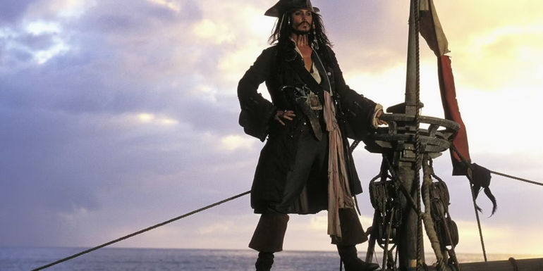 Johnny Depp as Jack Sparrow standing on his ship in Pirates of the Caribbean: The Curse of the Black Pearl
