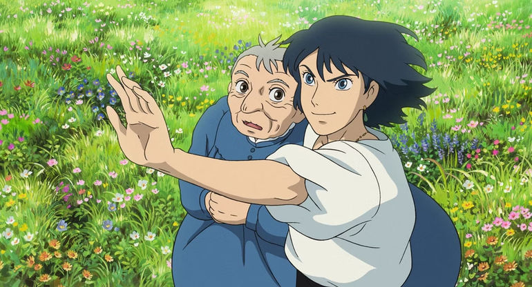 Howl's Moving Castle scene of Sophie as an elderly woman and Howl standing together in a field.