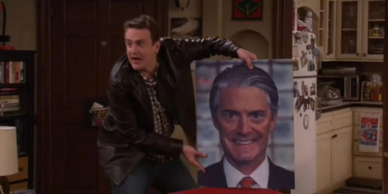 Jason Segel as Marshall Eriksen holding a large creepy picture of Kyle MacLachlan's The Captain in How I Met Your Mother