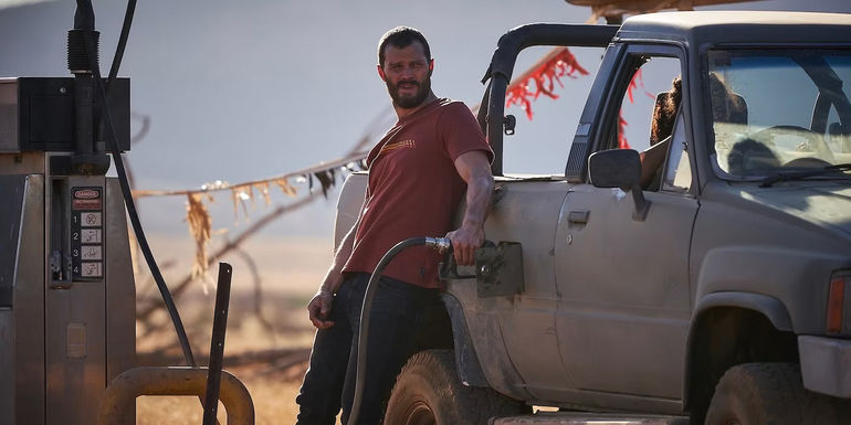 Jamie Dornan leaning against truck and putting gas in it in The Tourist