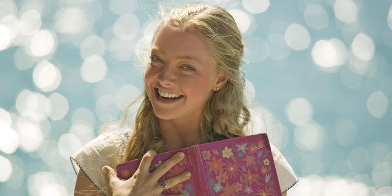 Sophie smiling and holding a diary to her chest