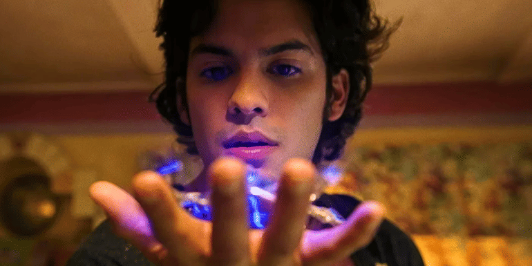 Xolo Maridueña as Jaime Reyes holding the Blue Beetle scarab.