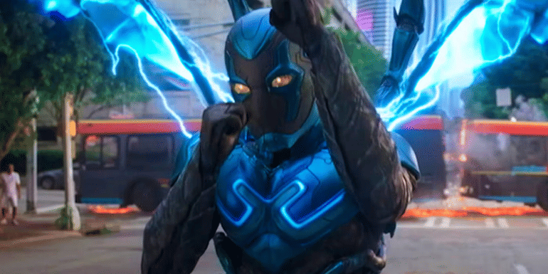 Xolo Maridueña as Jaime Reyes, holding his arms up in defense in Blue Beetle