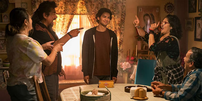 The Reyes family laughs around a dinner table in Blue Beetle