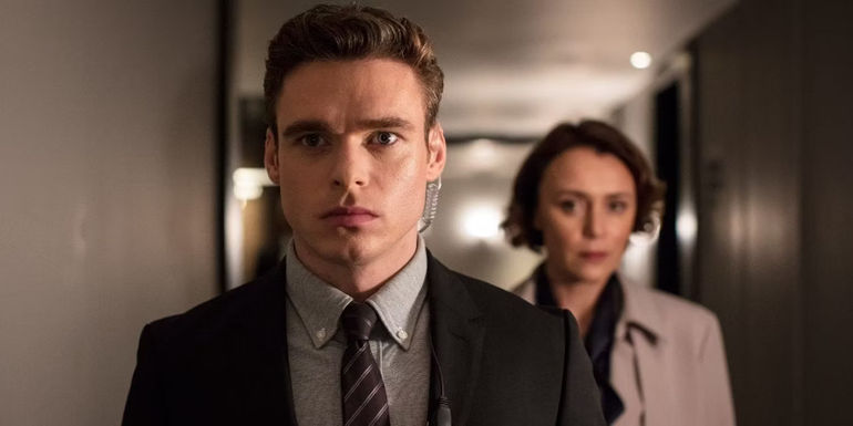 Richard Madden and Keeley Hawes standing in the hallway