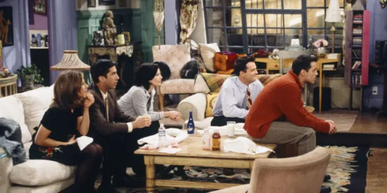 The main cast of Friends watching TV in Monica's apartment