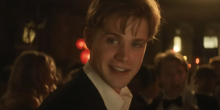 Dexter smiles while wearing a suit in One Day