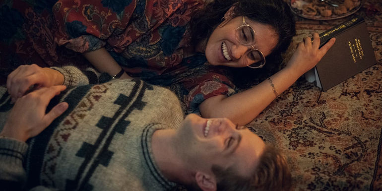 Em and Dex laugh while lying on the floor in One Day series