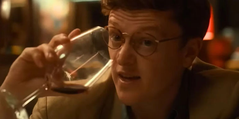 Ian goes to drink from a wine glass in One Day