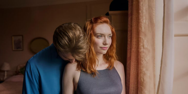 Dex puts his head on Sylvie's shoulder as she looks out the window in One Day