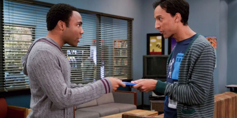 Donald Glover as Troy and Danny Pudi as Abed each holding the same DVD case in Community
