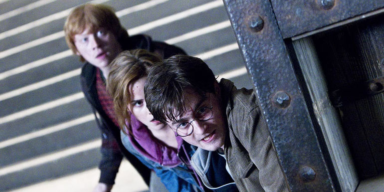 Harry Potter, Ron, and Hermione peeking around a corner in the Battle of Hogwarts