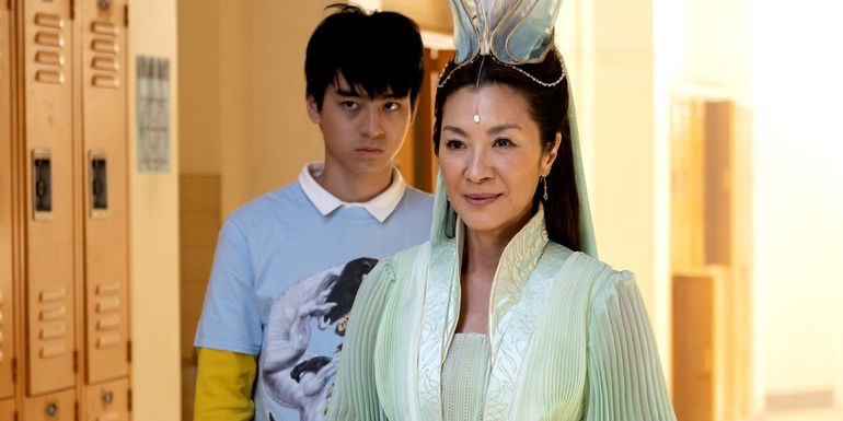 Ben Wang behind Michelle Yeoh standing in the school hallway in American Born Chinese