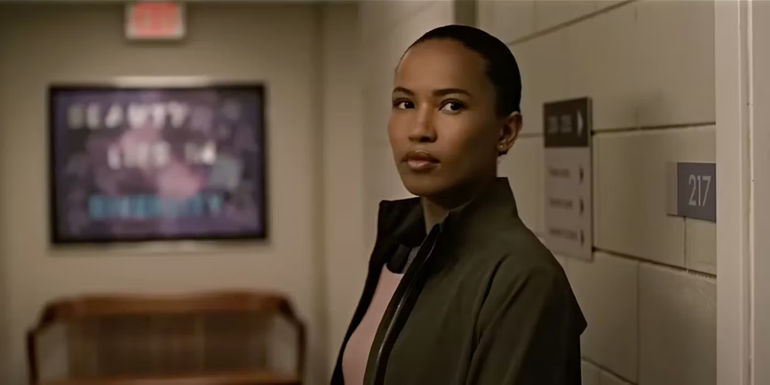 Chelsea looks serious while standing in the hallway in The Night Agent.