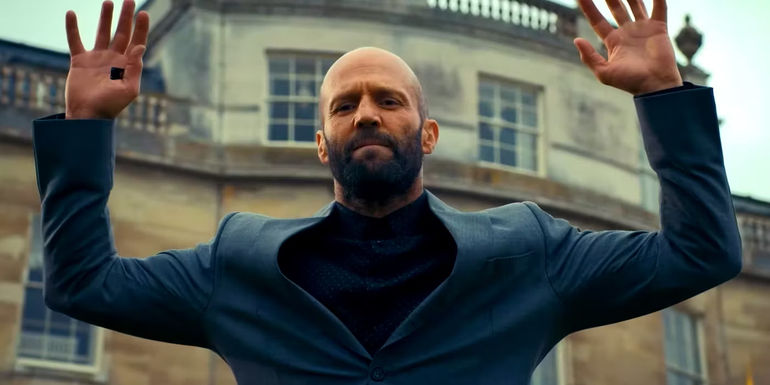 Jason Statham as Adam Clay Putting His Hands Up in The Beekeeper