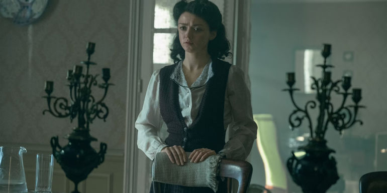 Maisie Williams As Catherine Dior Standing Behind A Chair In The New Look.jpg