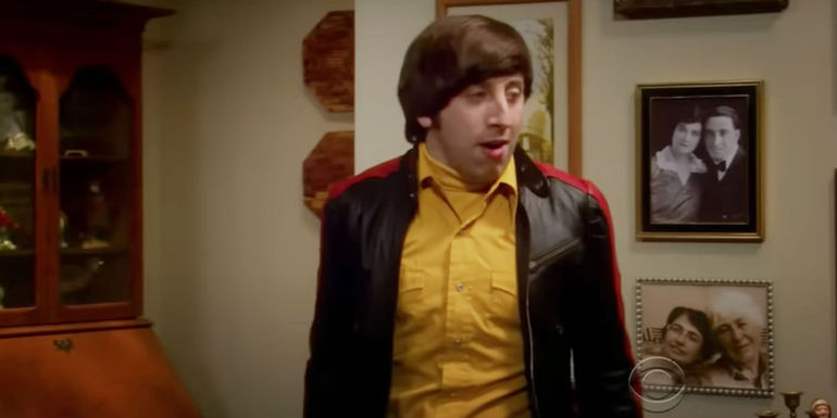 Howard (Simon Helberg) standing beside a portrait of his mom and dad's wedding in The Big Bang Theory