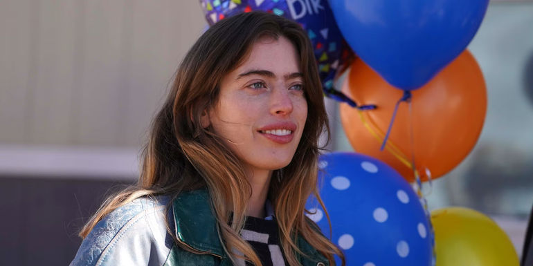 Clara McGregor smiling with birthday balloons behind her in Bleeding Love