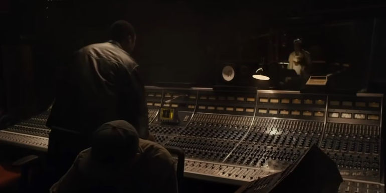 Dr. Dre (Corey Hawkins) talking to Tupac (Marcc Love) in a recording booth in Straight Outta Compton.