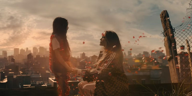 Bella Gagliano & Jennifer Lopez In This Is Me Now: A Love Story With Flower Petals In The Air Around Them.jpg