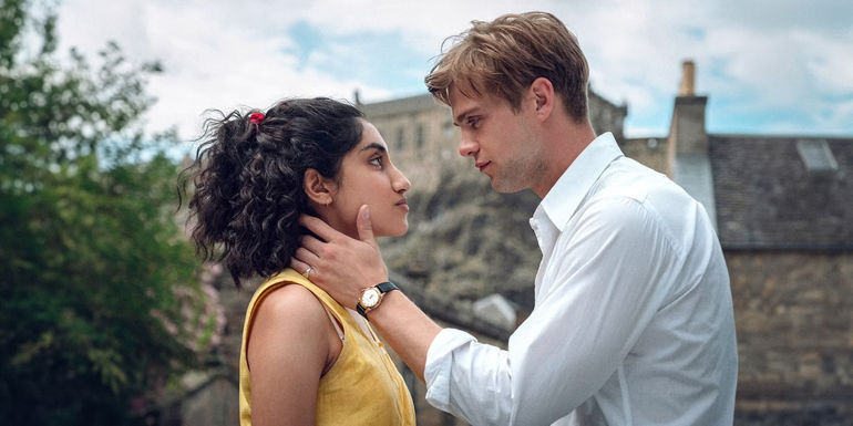 Dexter holds Emma's face while they look at each other in One Day