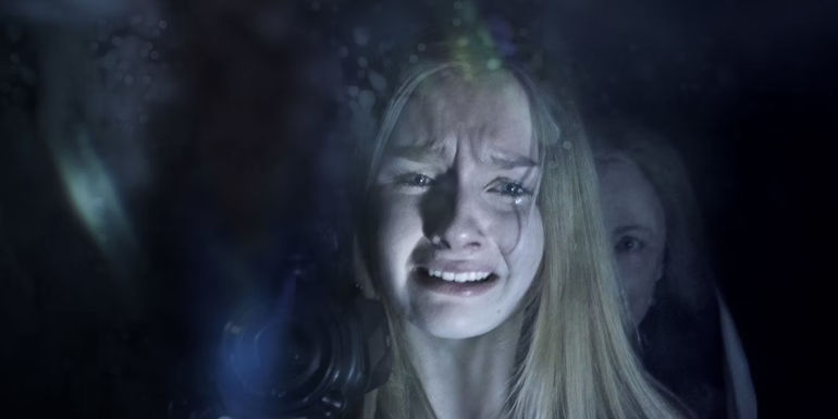 Deanna Dunagan as Nana sneaks up behind Olivia DeJonge as Becca in The Visit