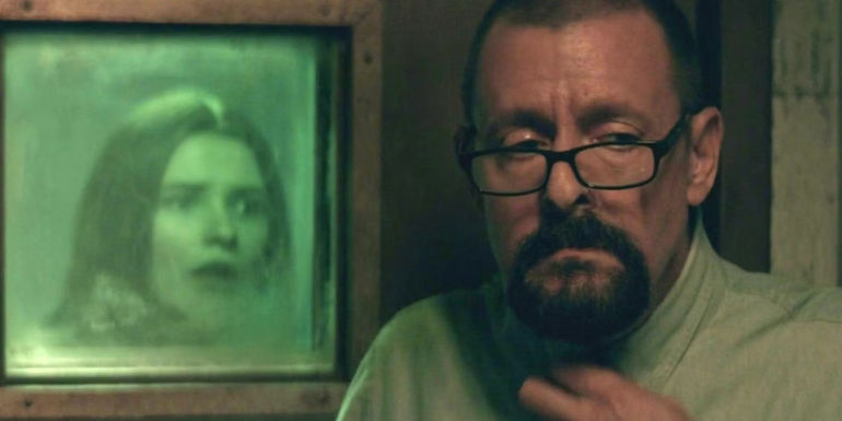 A girl behind a locked door looking at a man on the other side in Girl In The Basement