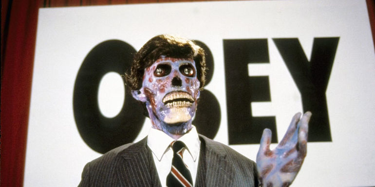 An alien standing before an OBEY sign in They Live - 1988 - They Live