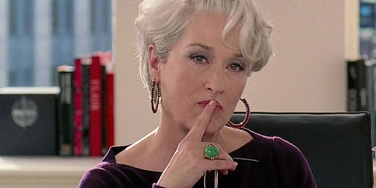 Miranda pondering at her desk in The Devil Wears Prada