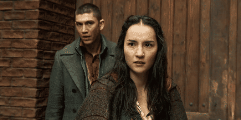 Archie Renaux's Malyen standing behind Jessie Mei Li's Alina in Shadow & Bone