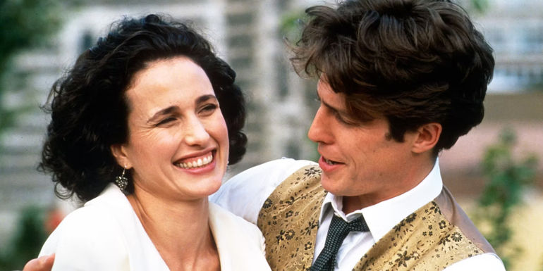 Carrie (Andie MacDowell) smiling hugged by Charles (Hugh Grant) in Four Weddings and a Funeral