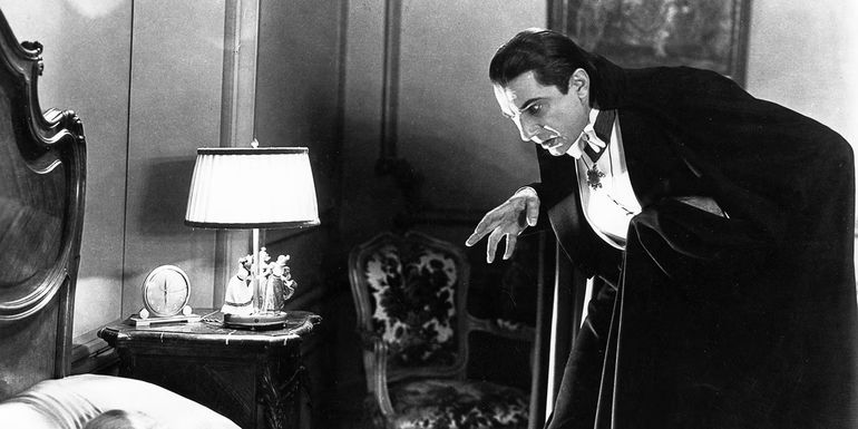 Bela Lugosi as Dracula approaching a woman in bed