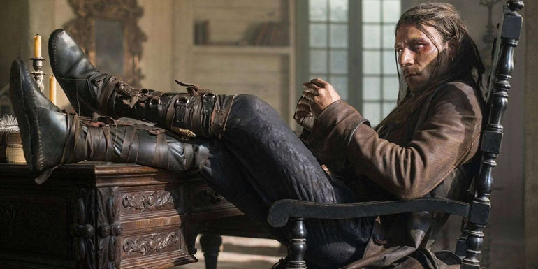 Charles Vane glares as he sits in a chair with his feet kicked up on his desk in Black Sails.