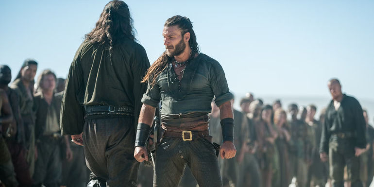 Charles Vane stands with his back to a line of pirates in Black Sails.