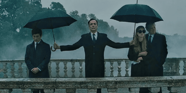 Duncan holds umbrellas for the Cattons and Oliver, who are all standing on a bridge in Saltburn.