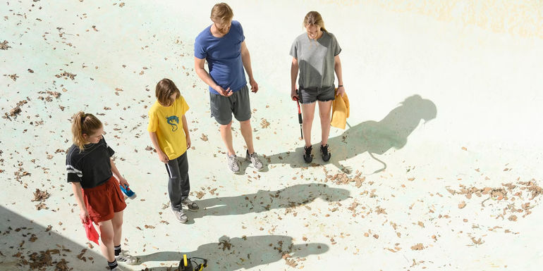 The Waller family assesses the state of the pool in Night Swim
