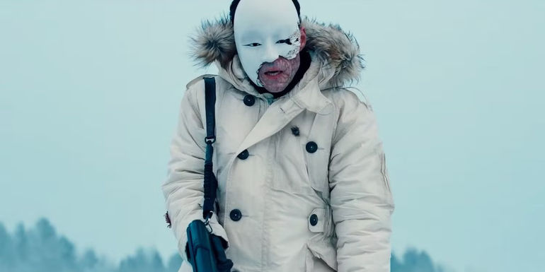 Safin wearing a broken mask in the opening scene of No Time to Die