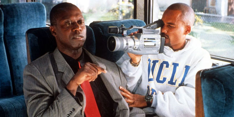 Flip sitting on a bus with a camera pointed at him in Get on the Bus